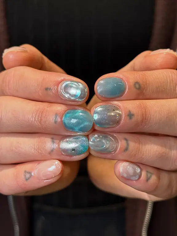Krótki manicure z niebieskim chromem i wypukłymi zdobieniami